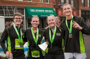a relay running team smiling and posing for a photo